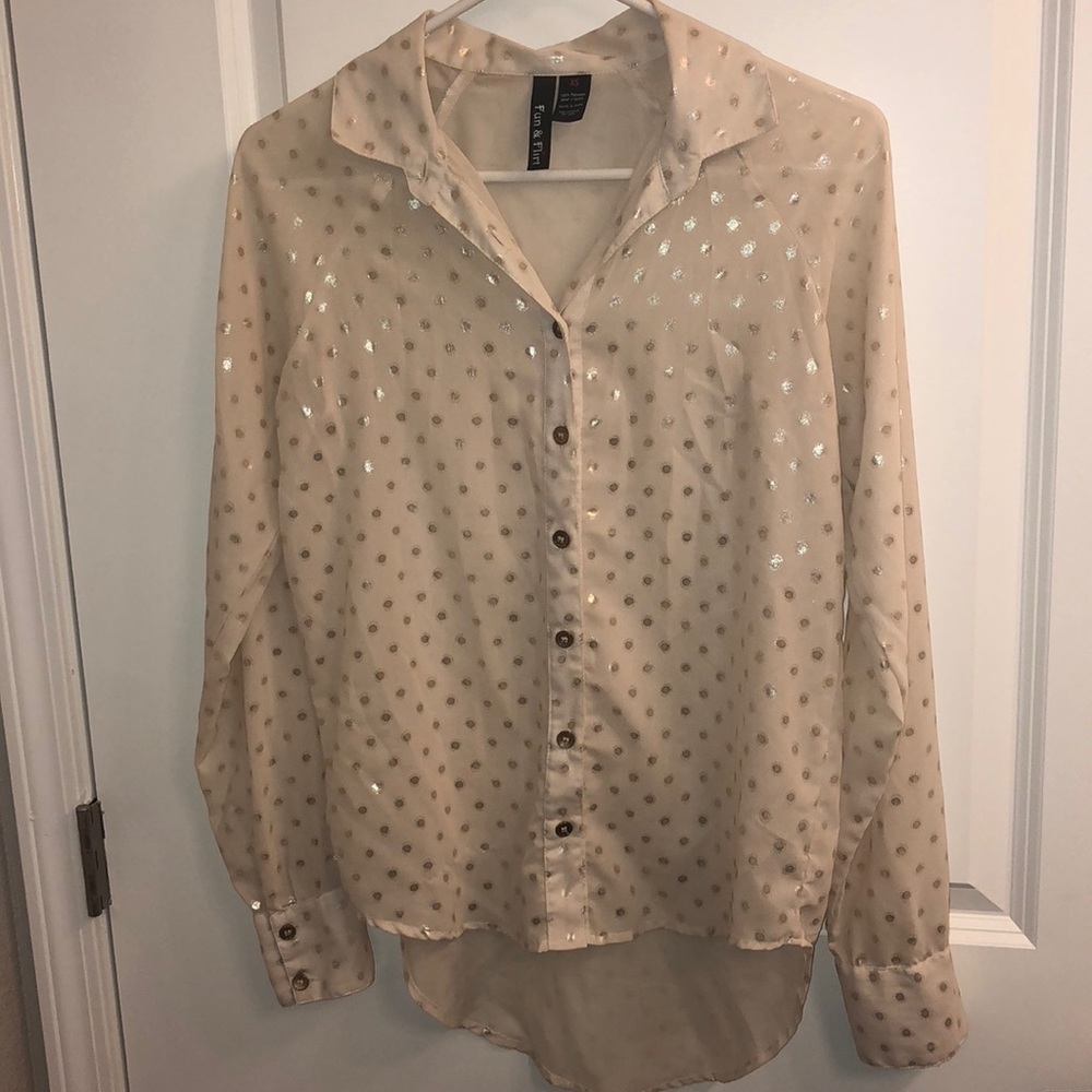 Cream blouse with gold polka dots.